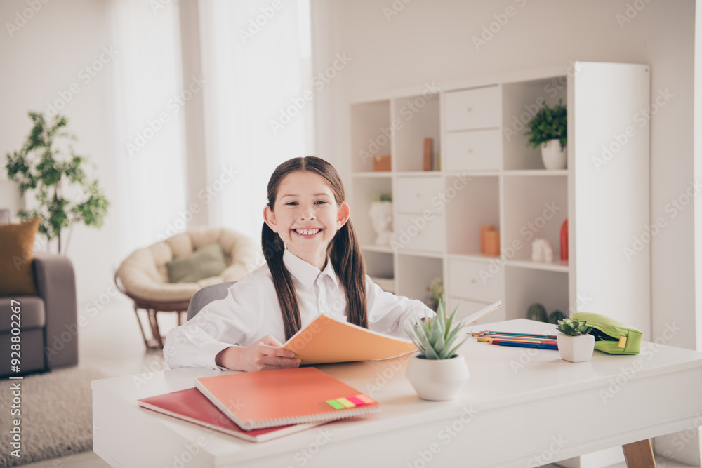Photo portrait of cute adorable girl cheerful smile homework textbook remote lesson education from home indoors Photo portrait of cute adorable girl cheerful smile homework textbook remote lesson education from home indoors