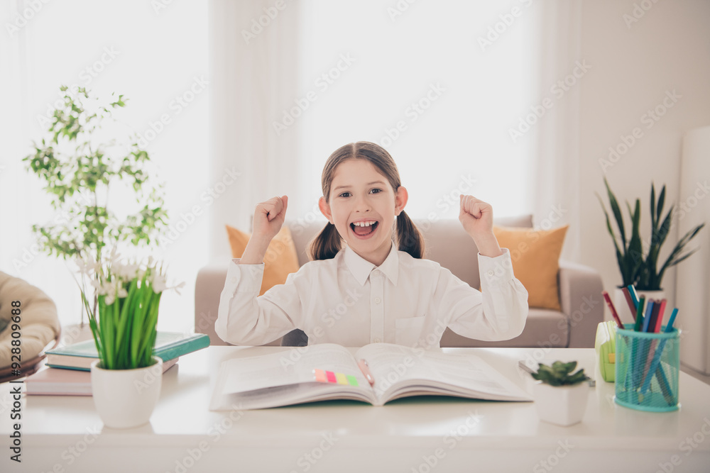 Photo portrait of cute adorable girl raise fists winning remote lesson education from home indoors Photo portrait of cute adorable girl raise fists winning remote lesson education from home indoors