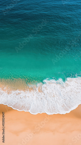 Aerial view of a tropical beach with turquoise water and golden sand, as gentle waves wash onto the shore. The scene is tranquil and refreshing.