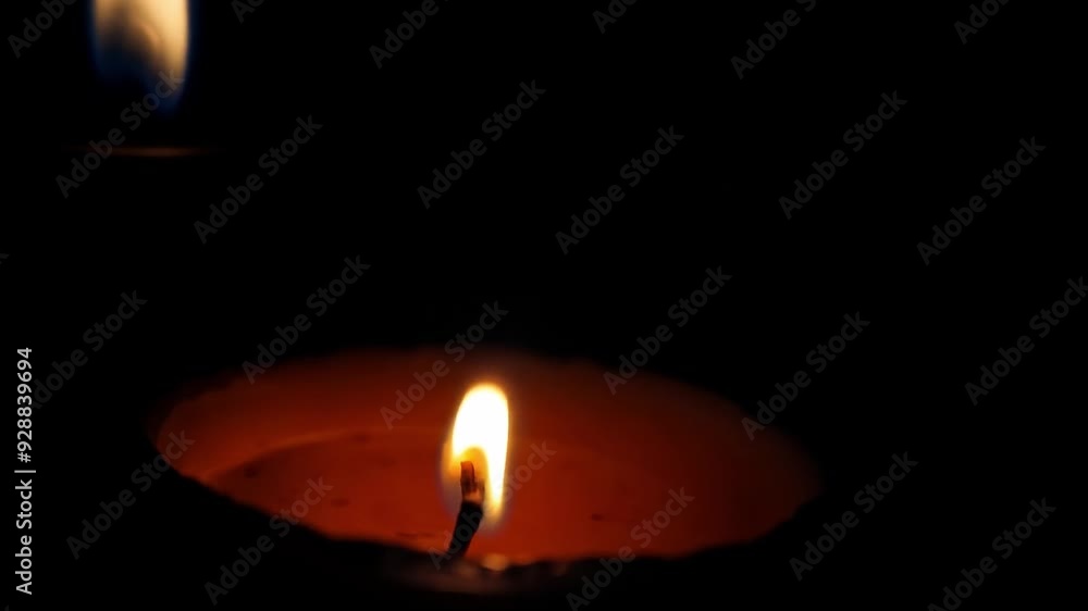 Glowing candle flame in dim light with bokeh effect Glowing candle flame in dim light with bokeh effect