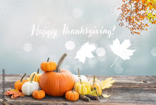 pile of raw orange pumpkins with fall leaves on wooden table, defucused garden background with copy space photo