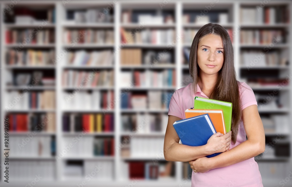 A focused young smart woman standing in bookstore. A focused young smart woman standing in bookstore.