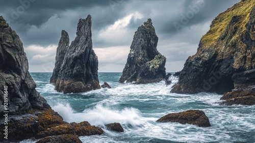 Dramatic coastal scene with rocky formations and turbulent waves under a cloudy sky.