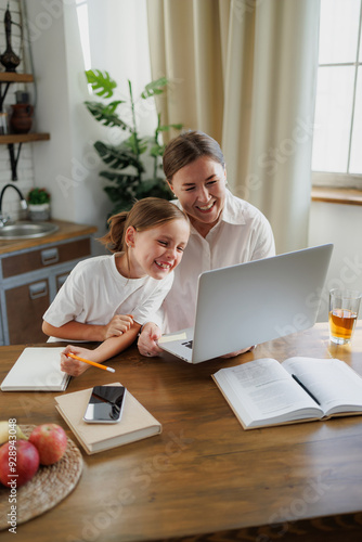 Positive family using laptop near books at home