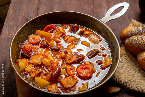 Hot cholent in a cast iron pan on the festive table for the Rosh Hashanah meal photo