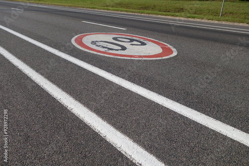 Sixty speed limit sign on asphalt road.