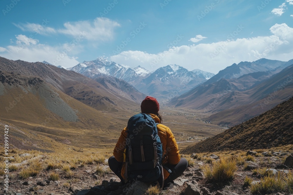 Fototapeta premium A traveler rests, taking in an awe-inspiring mountain view.