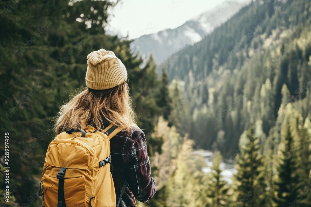 Female hiker views forest mountains with yellow backpack Female hiker views forest mountains with yellow backpack
