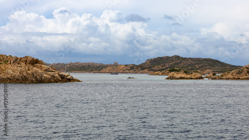 La costa rocosa de la isla de Santa Maria, Cerdeña, se extiende hacia el horizonte bajo un cielo nublado en primavera. El paisaje está dominado por grandes formaciones de granito.