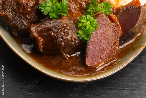 Stewed goose stomach.  Traditional Polish meat on a dark background.