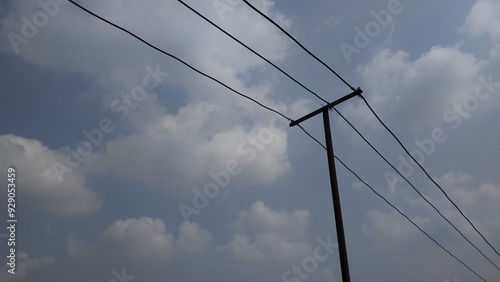 Wallpaper Mural  An upward view of power lines stretching across a cloudy sky. The image captures the simplicity of infrastructure against a natural backdrop, making it ideal for themes of connectivity or energy. Torontodigital.ca