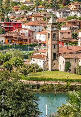 The bell tower of the ancient church of Saints Peter and Paul in Lavena Ponte Tresa, Varese, overlooks Lake Lugano, province of Varese, Lombardy, Italy photo