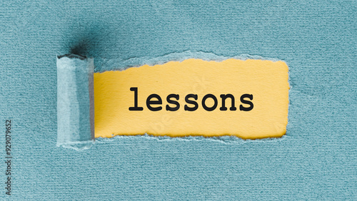 A yellow piece of paper has been torn to reveal the word lessons written in black on a blue background.