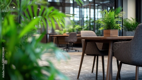 A bright office features plants surrounding stylish furniture, creating a calm and inviting atmosphere for work