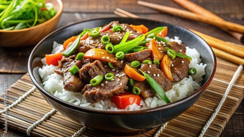 Savory Japanese-inspired beef and rice bowl with grilled strips of marinated beef, steamed white rice, and stir-fried vegetables, garnished with green onions.