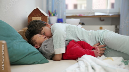 Older sibling embraces baby on a bed, creating a tender and heartwarming moment in a cozy, sunlit room filled with love, affection, and the warmth of family bonds