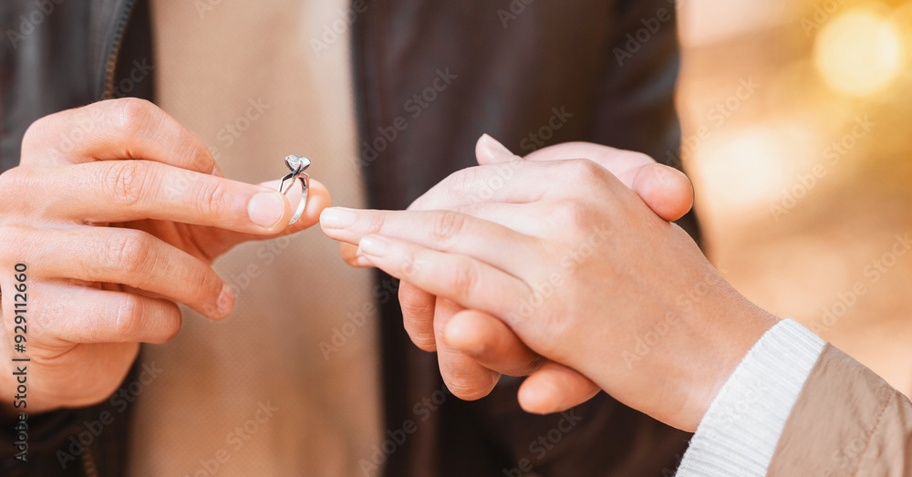 CLose up of man putting engagement ring on female finger outdoors, marriage and engagement concept CLose up of man putting engagement ring on female finger outdoors, marriage and engagement concept