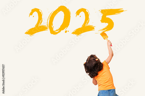 Cute little girl drawing new year 2025 with painting brush on wall background