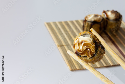 Wallpaper Mural Pair of chopsticks holding a hot roll in front of two other rot holls that are out of focus Torontodigital.ca