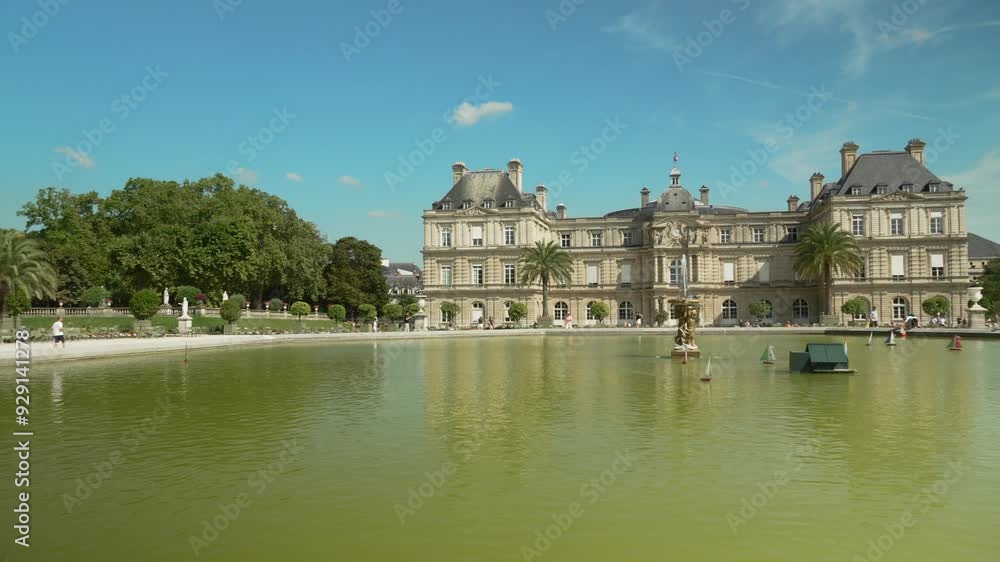 Crowd of tourists walking near the Luxembourg Palace in Paris, small boats with flags of different countries floating in a fountain in the Luxembourg Garden Crowd of tourists walking near the Luxembourg Palace in Paris, small boats with flags of different countries floating in a fountain in the Luxembourg Garden