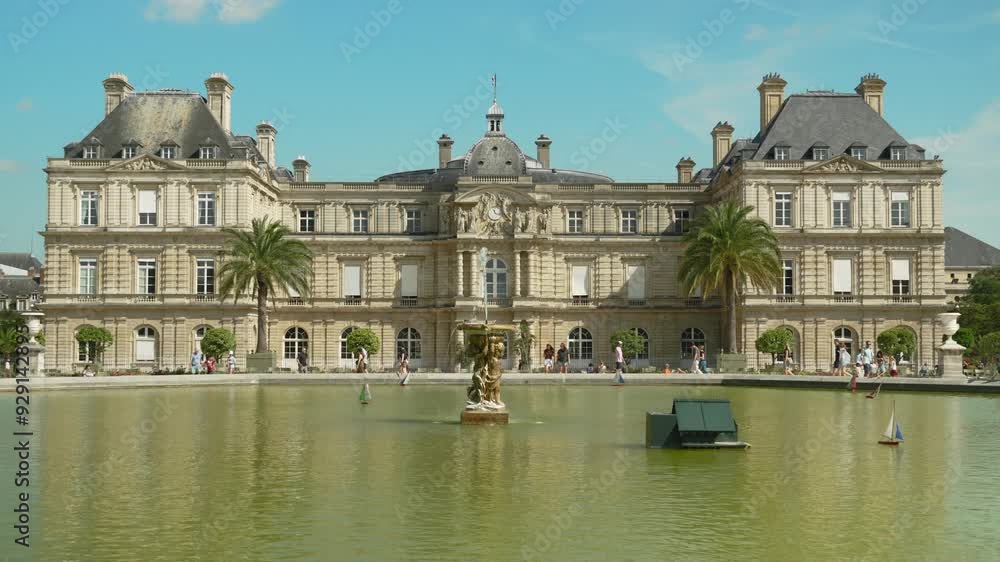 Crowd of tourists walking near the Luxembourg Palace in Paris, small boats with flags of different countries floating in a fountain in the Luxembourg Garden Crowd of tourists walking near the Luxembourg Palace in Paris, small boats with flags of different countries floating in a fountain in the Luxembourg Garden