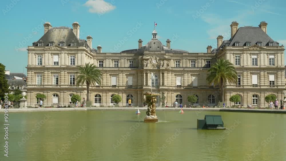 Crowd of tourists walking near the Luxembourg Palace in Paris, small boats with flags of different countries floating in a fountain in the Luxembourg Garden Crowd of tourists walking near the Luxembourg Palace in Paris, small boats with flags of different countries floating in a fountain in the Luxembourg Garden
