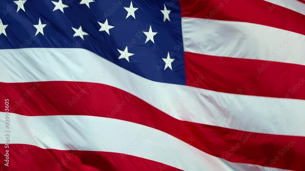 Real American flag waving in the wind in slow motion, with vibrant red white and blue colors against blue sky, 4k, with copy space. Real American flag waving in the wind in slow motion, with vibrant red white and blue colors against blue sky, 4k, with copy space.