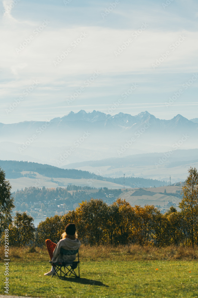 Girl sitting on chair looking at mountain landscape Girl sitting on chair looking at mountain landscape