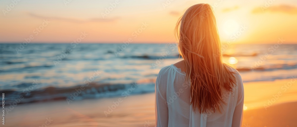 A woman's profile facing the tranquil ocean at sunset on the beach A woman's profile facing the tranquil ocean at sunset on the beach