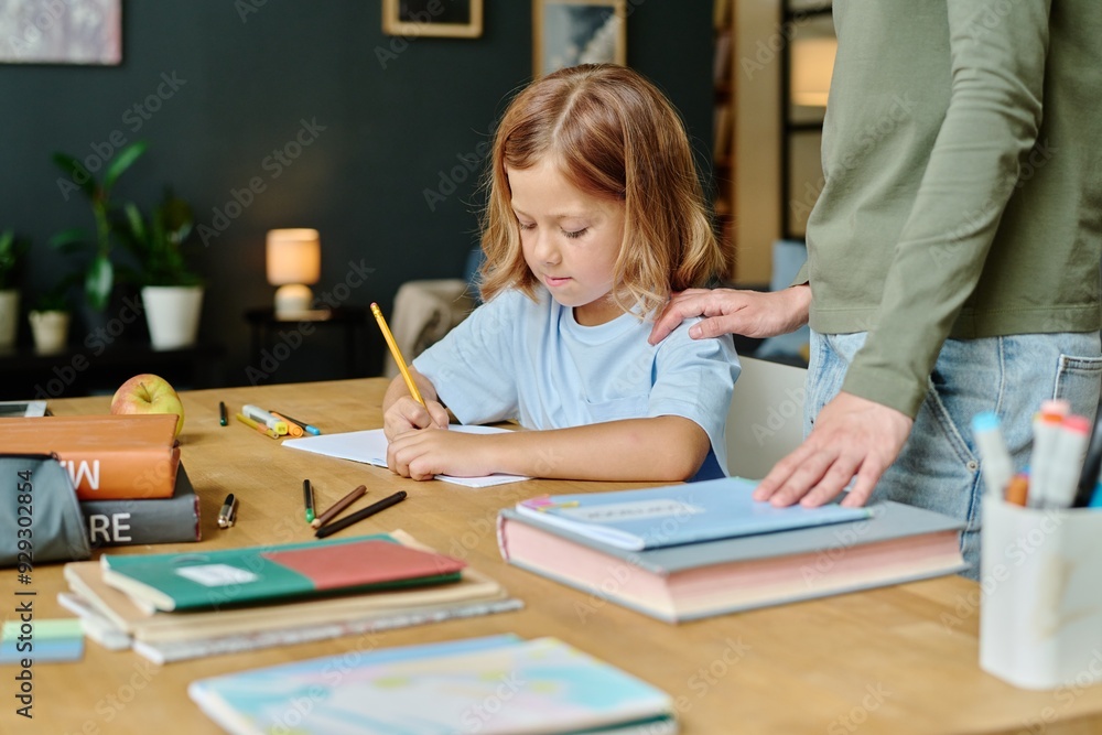 Little girl doing sums while her mother supporting her Little girl doing sums while her mother supporting her