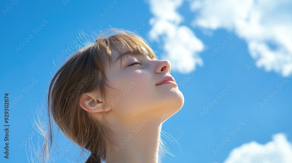 A serene young Caucasian girl enjoying a sunny day, with her eyes closed and face uplifted toward a clear blue sky. A serene young Caucasian girl enjoying a sunny day, with her eyes closed and face uplifted toward a clear blue sky.