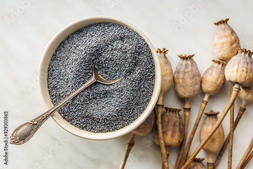 Tableau sur toile Dry poppy head and poppy seed in bowl on kitchen table. Top view.