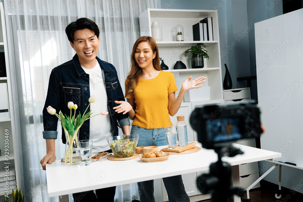 Cooking show on live streaming with two chef influencers teaching mixed salad with dressing for easy special recording on video camera. Ingredients placing bread bun wholegrain side dish. Infobahn. Cooking show on live streaming with two chef influencers teaching mixed salad with dressing for easy special recording on video camera. Ingredients placing bread bun wholegrain side dish. Infobahn.