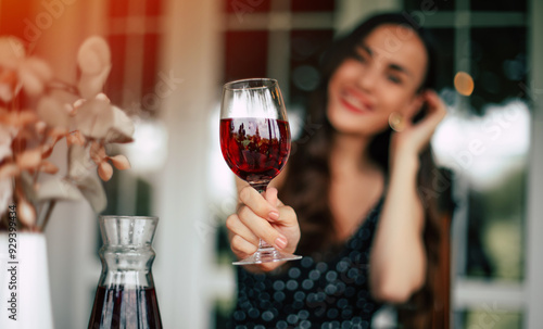 Canvas Print A glass of high-quality and aged red wine in the hand of a smiling brunette woma