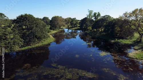 Drone footage of a pond and trees in a rural Oklahoma pasture