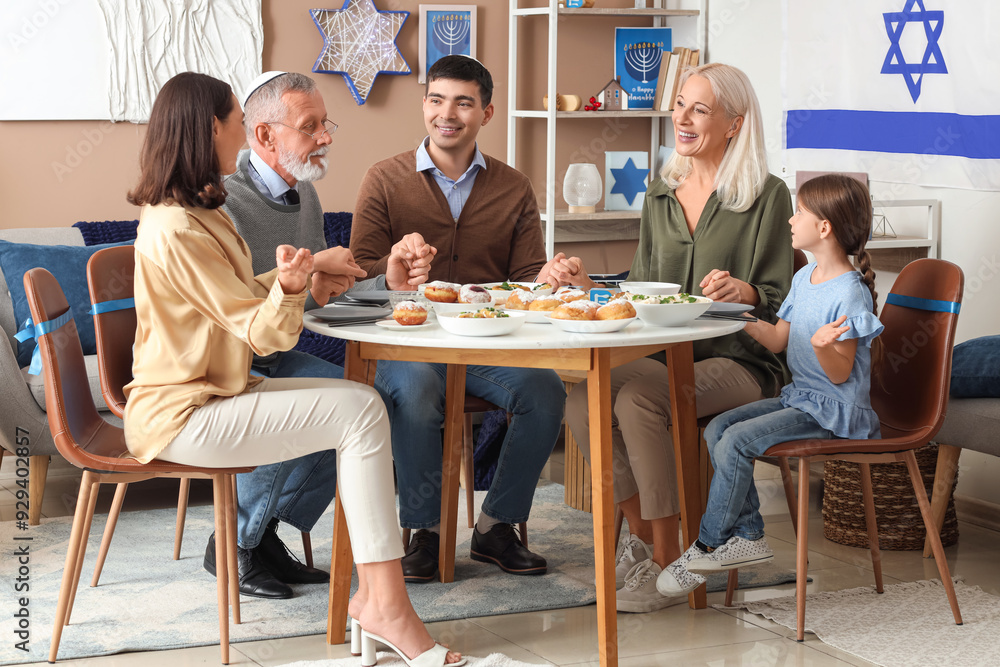 Happy Jewish family having dinner at home on Hanukkah Happy Jewish family having dinner at home on Hanukkah