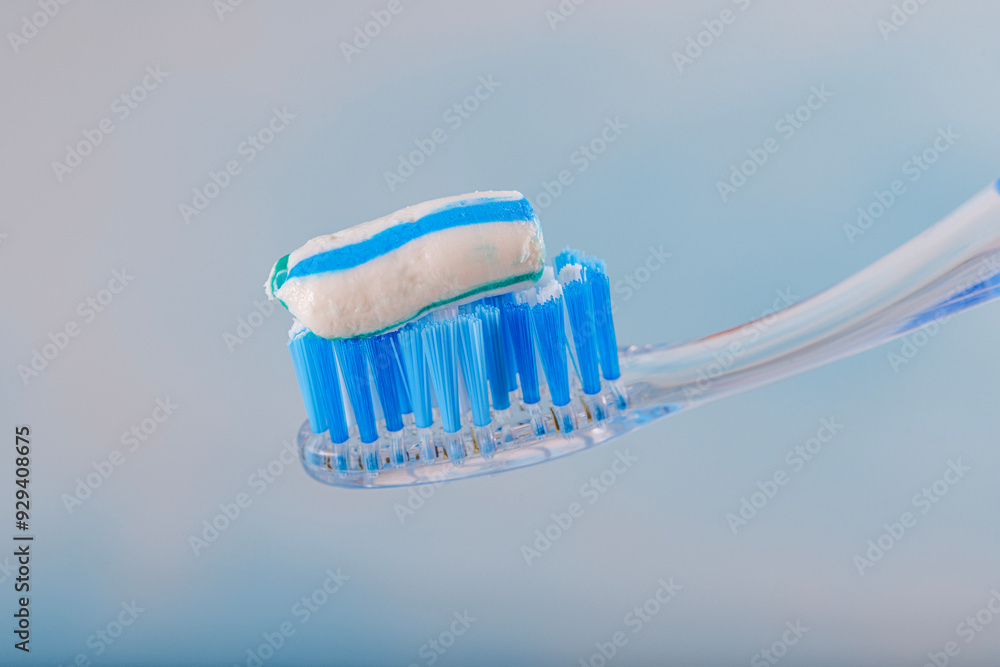 Toothbrush and toothpaste, Squeezing toothpaste onto toothbrush. Applying toothpaste on brush against blurred background, closeup. Toothbrush and toothpaste, Squeezing toothpaste onto toothbrush. Applying toothpaste on brush against blurred background, closeup.