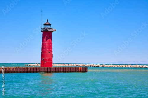 Red Lighthouse on Metal Pier Extending into Turquoise Waters at Eye Level