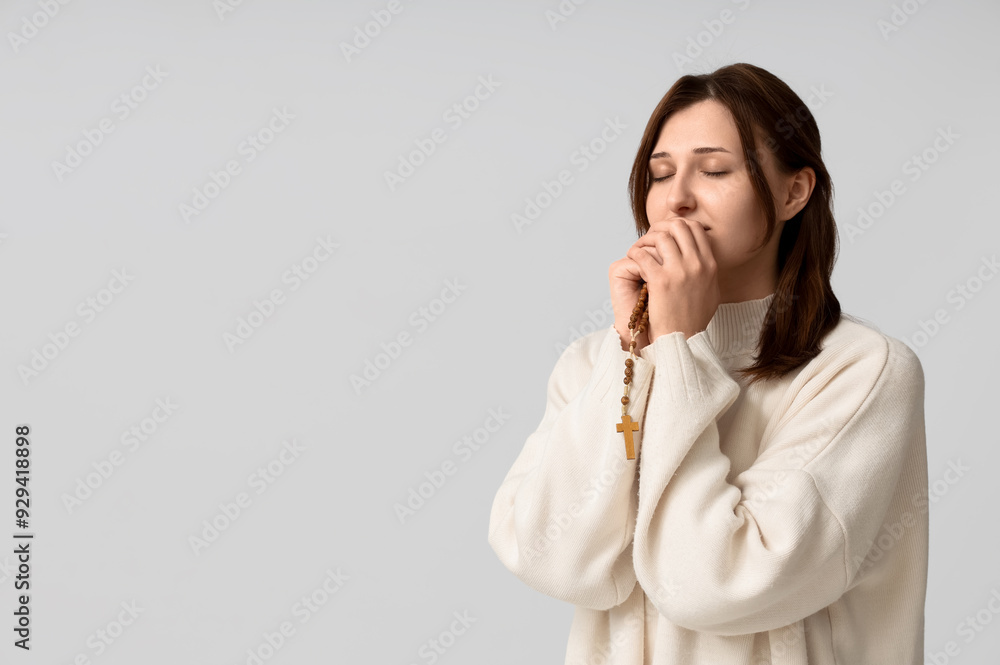 Religious young woman with rosary beads praying on white background Religious young woman with rosary beads praying on white background
