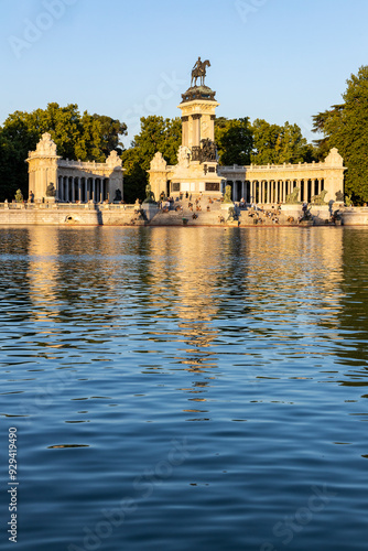Retiro Park, Madrid, Spain. Crystal Palace, lake with swans, glass structure, architecture. Lake and temple on the horizon, fountains and decorated with colorful plants and flowers, family leisure.