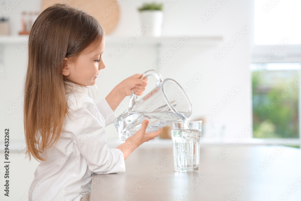 Cute little girl pouring water into glass in kitchen Cute little girl pouring water into glass in kitchen