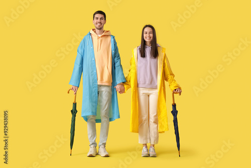 Young couple in raincoats o...