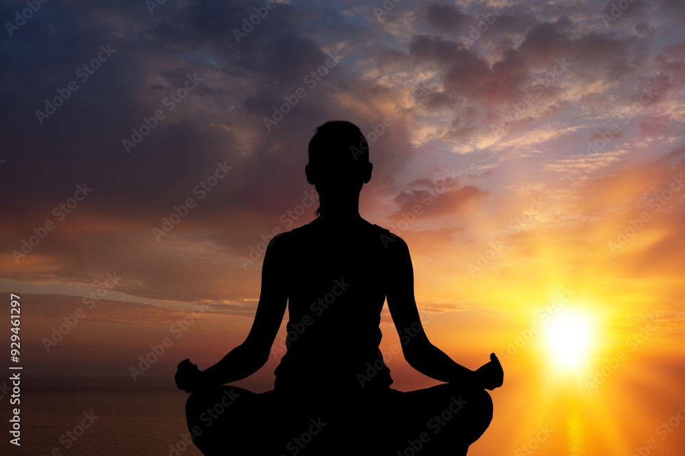 Experience of yoga on beach at sunset, silhouette of woman Experience of yoga on beach at sunset, silhouette of woman