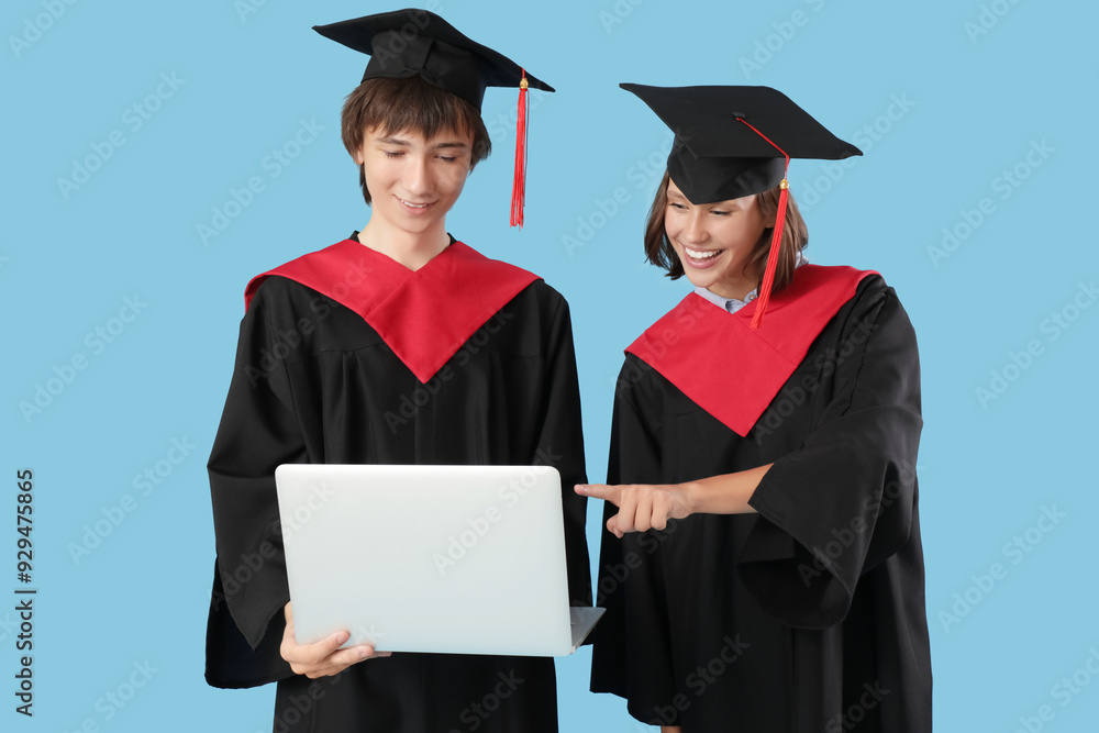 Graduating students with laptop on blue background Graduating students with laptop on blue background