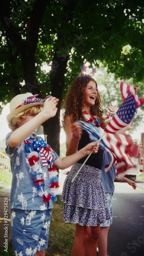 Young Boy And Teenage Girl Celebrating Fourth Of July By Waving US Flags