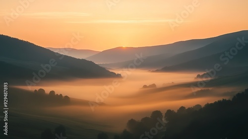 A long exposure shot of moving fog in a valley at dawn, with a faint orange glow from the rising sun