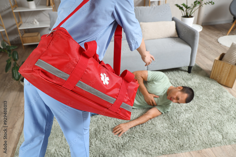 Female doctor with first aid bag and man having heart attack at home