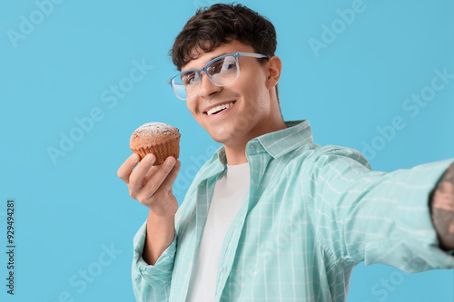 Young man with tasty muffin...