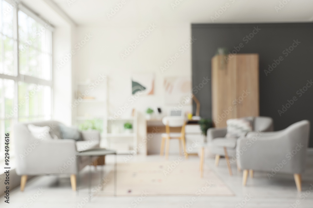 Blurred view of living room with sofa, armchairs and workplace Blurred view of living room with sofa, armchairs and workplace
