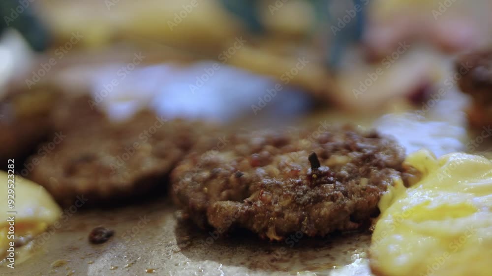 Cook checking doneness of hamburger patties on griddle Cook checking doneness of hamburger patties on griddle